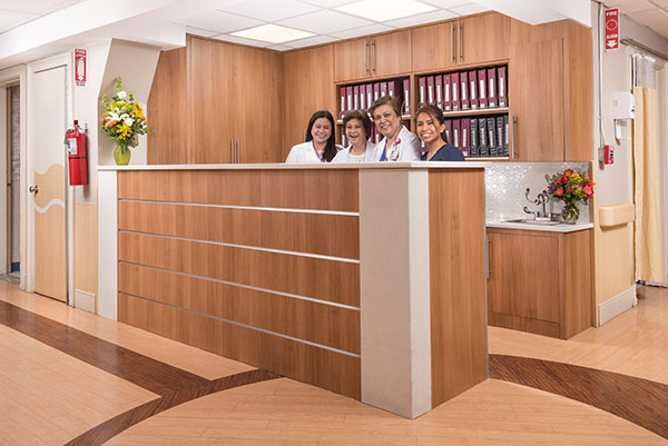 four team members standing behind the main reception desk